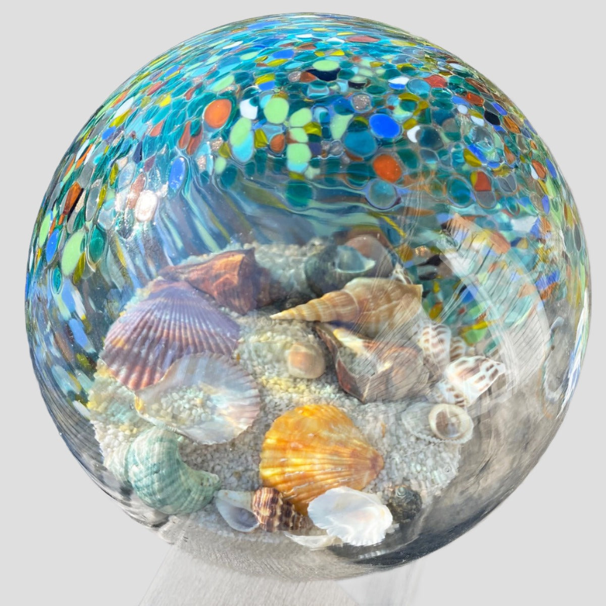 Beautiful hand blown glass globe filled with shells and beach sand.